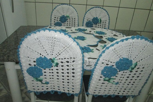 Capa de crochê para cadeira branca com flores azuis
