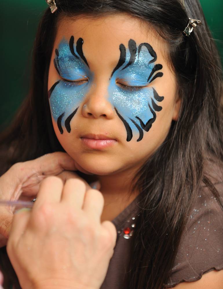 Pintura de rosto de borboleta azul em criança