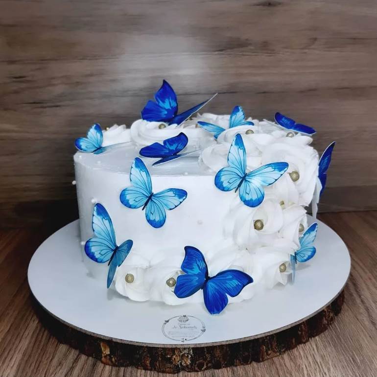 Bolo branco com insetos voadores azuis